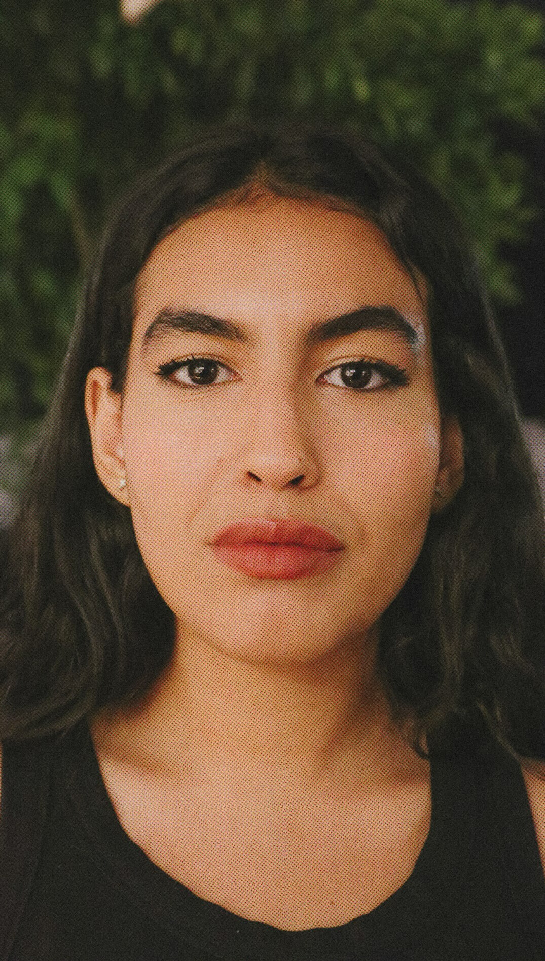 Studio portrait of a Latin American woman in her forties, editor-in-chief, wearing smart casual clothing