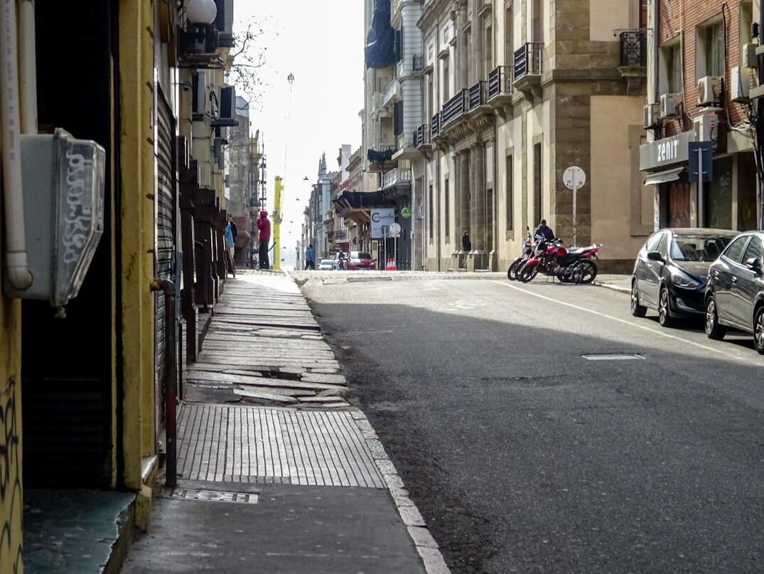 Empty cobblestone street in Montevideo old town at dusk with warm streetlights